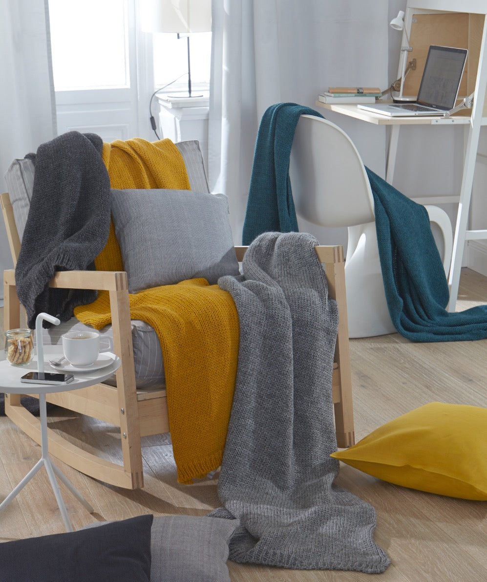 Gestrickte Decke in grau, gelb und Petroleum. Strickoptik 